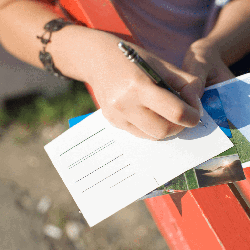 6 Ideen, damit dein Kind Spaß am Schreiben hat. Idee 4: Postkarten im Ständer, werden geschrieben, sind ausgebreitet.